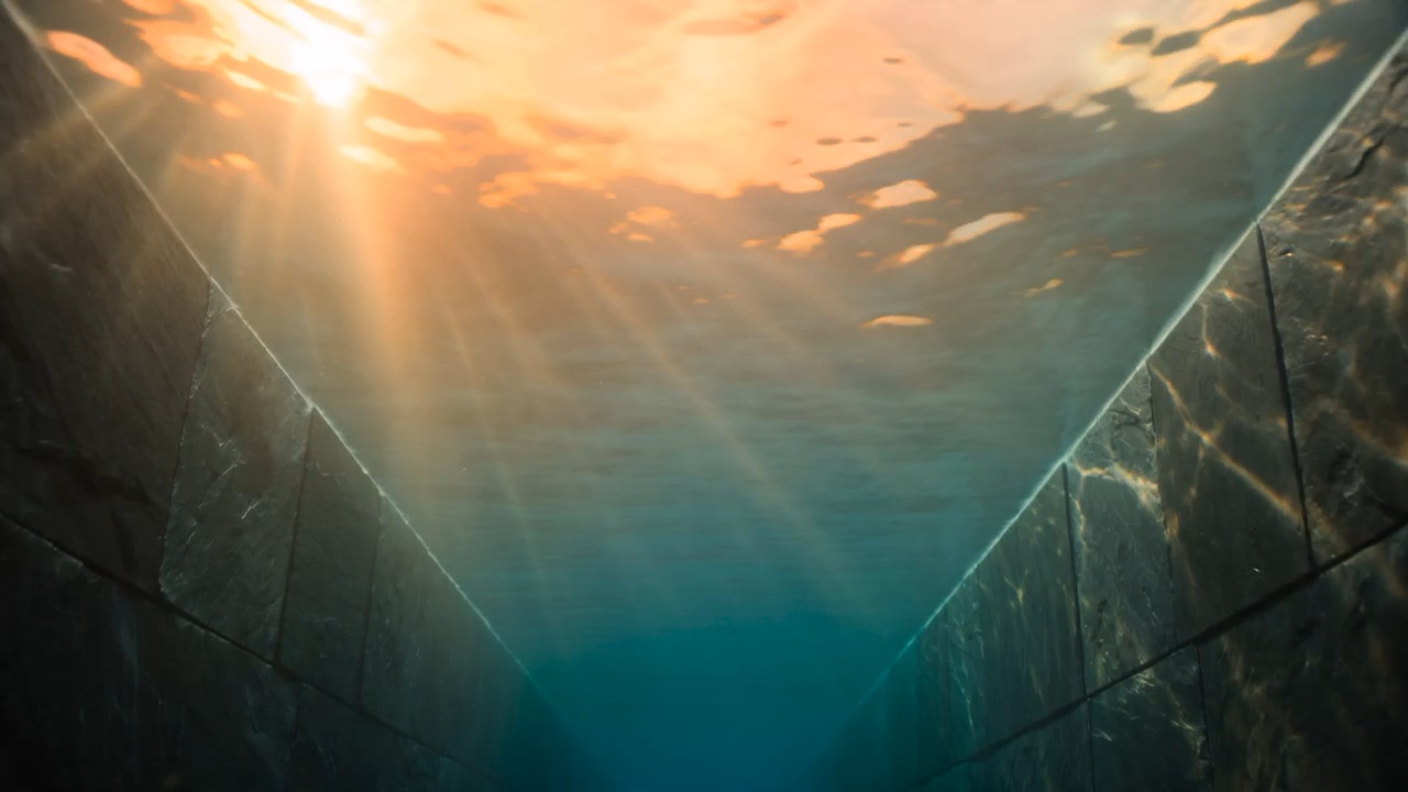 Sunset light refracting through a pool surface seen from just beneath the waterline